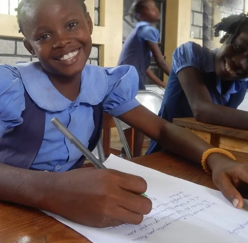 A HEART student writing at her desk