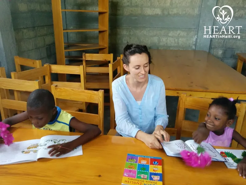 A teacher reading with students at the HEART School