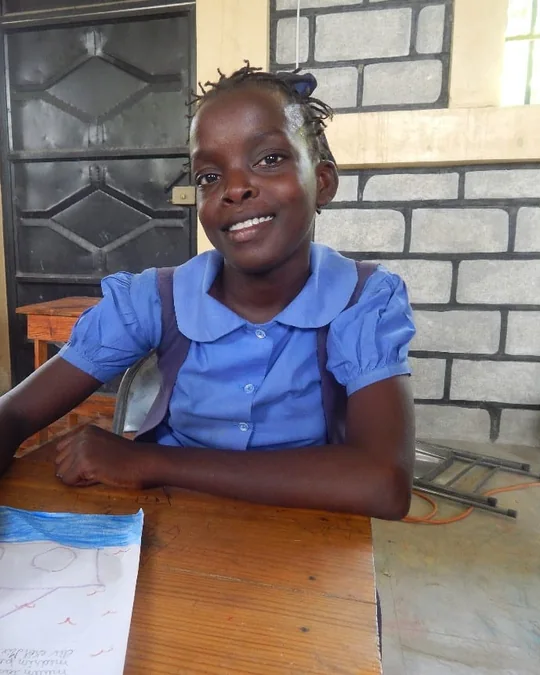 A student smiling at her desk